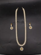 Three-line freshwater pearl long haram set with sunburst floral pendant and matching floral earrings.