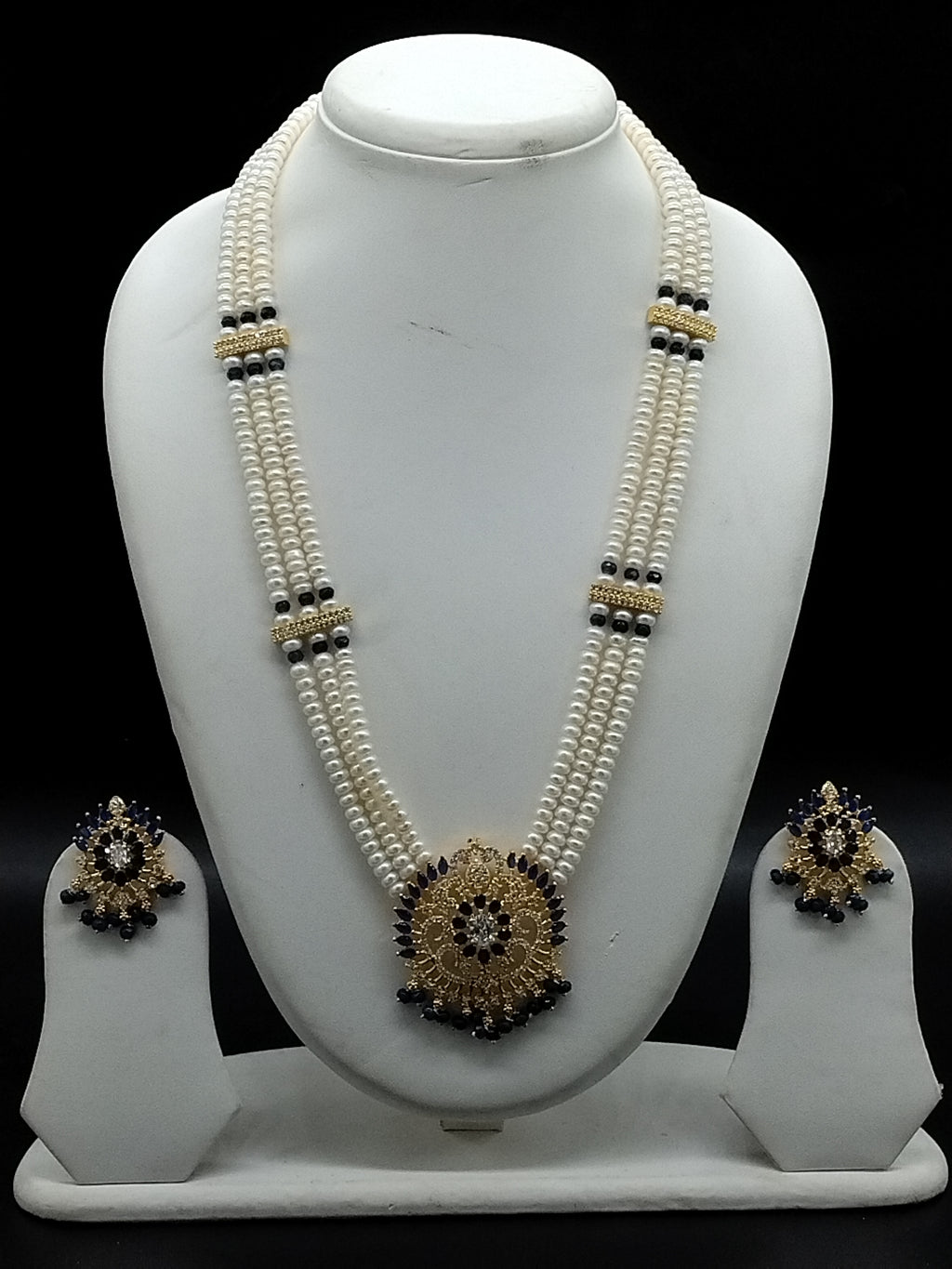 Three-line white freshwater pearl Rani Haar necklace set with blue stone pendant and matching earrings