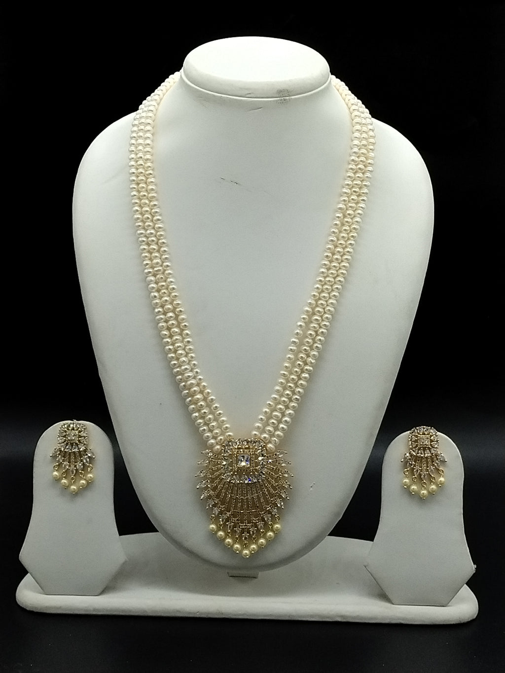 Three-line white freshwater pearl Rani Haar necklace set with gold-toned pendant and matching earrings