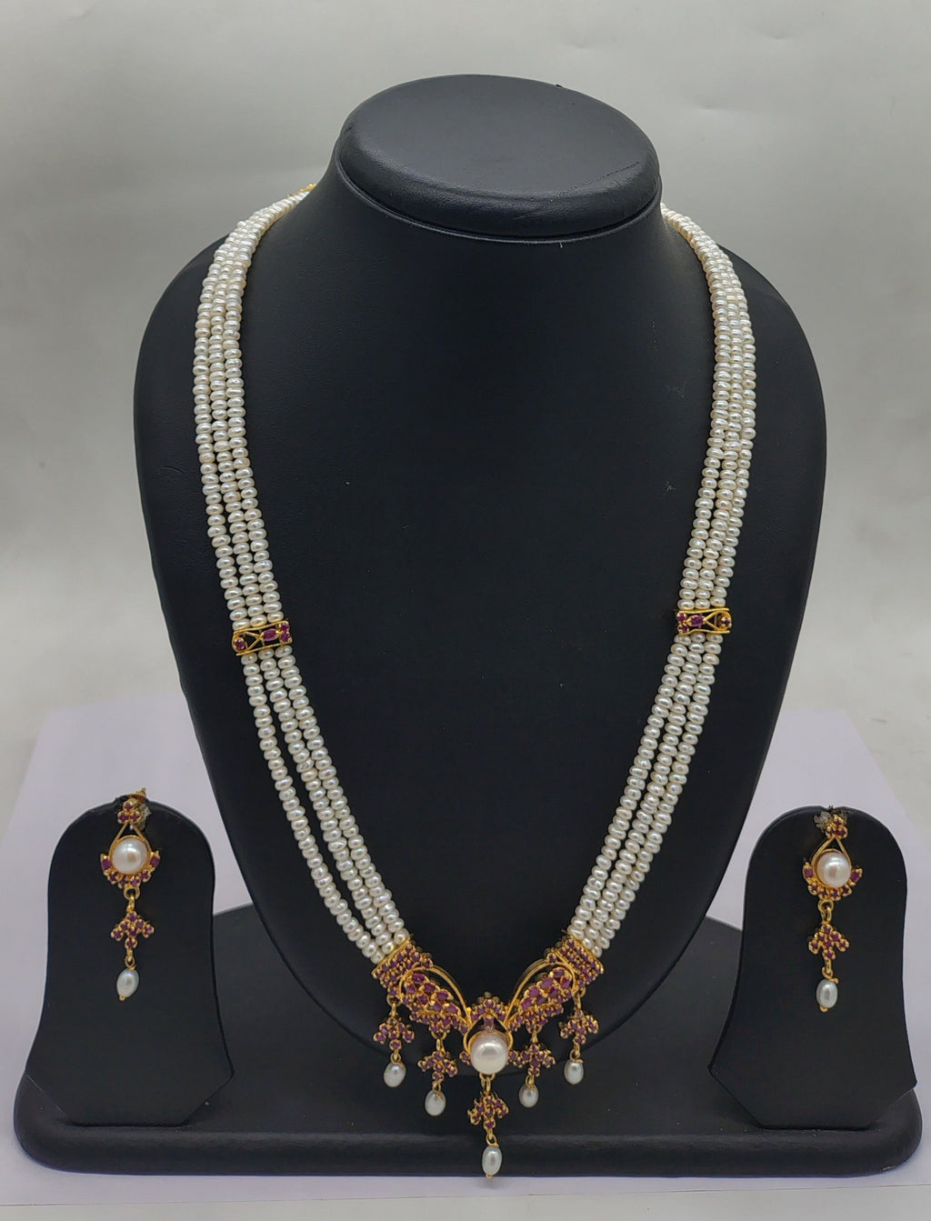 Three line freshwater pearl pendant necklace set with white flat pearls and pink stone pendant