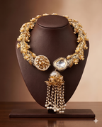 Traditional Hasli necklace set with white Kundan stones, fancy pearls, floral motifs, and pearl tassel centerpiece.