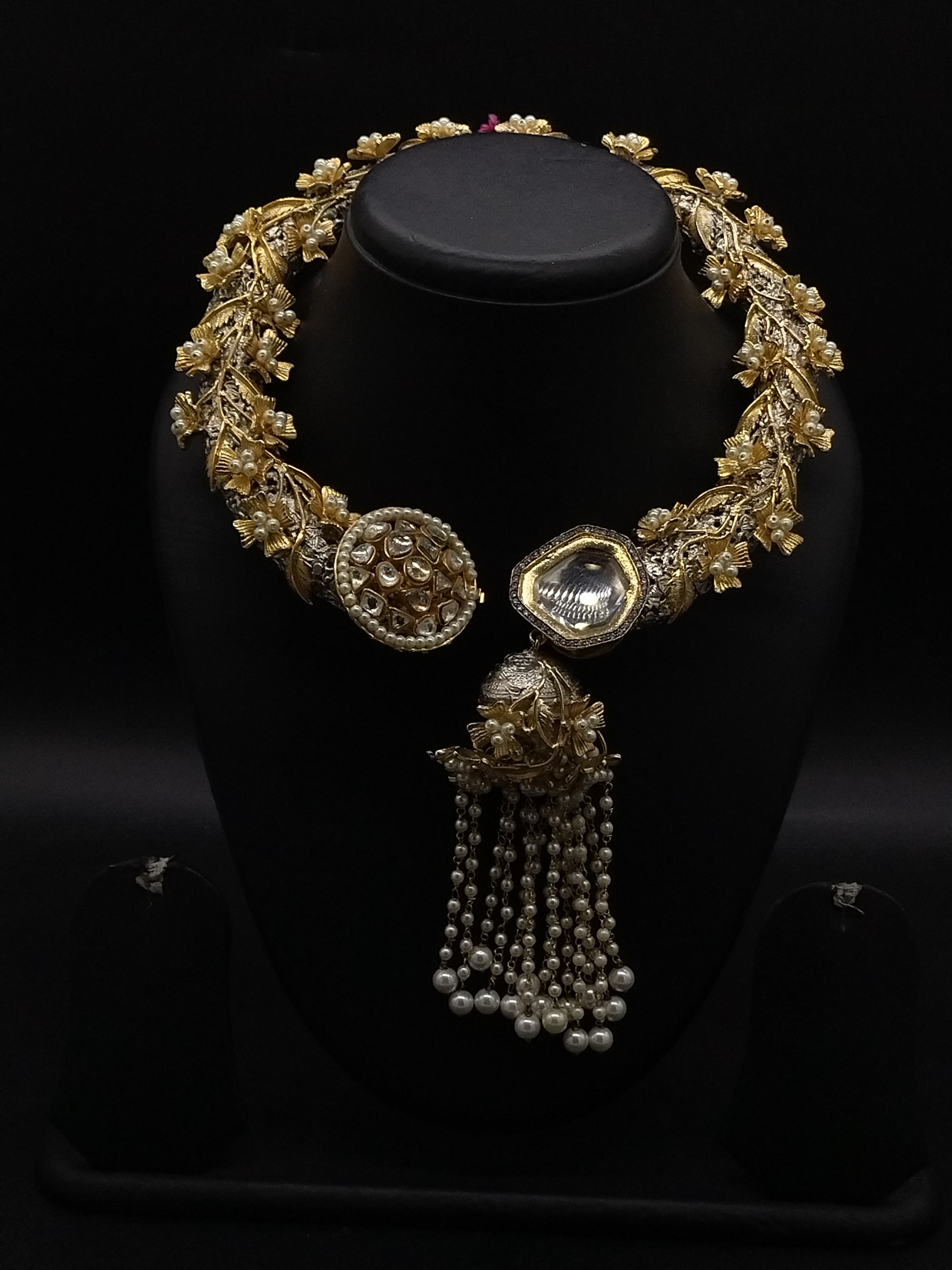 Traditional Hasli necklace set with white Kundan stones, fancy pearls, floral motifs, and pearl tassel centerpiece.