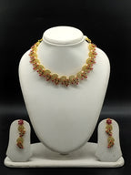 Traditional temple necklace set with red and green stones, floral and mango motifs, and matching drop earrings.