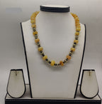 amber beaded necklace with pumpkin yellow beads and silver spacers in symmetrical design