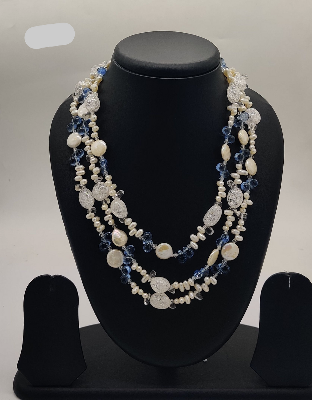 freshwater pearl necklace with blue beads and clear carved accents in multi layer design