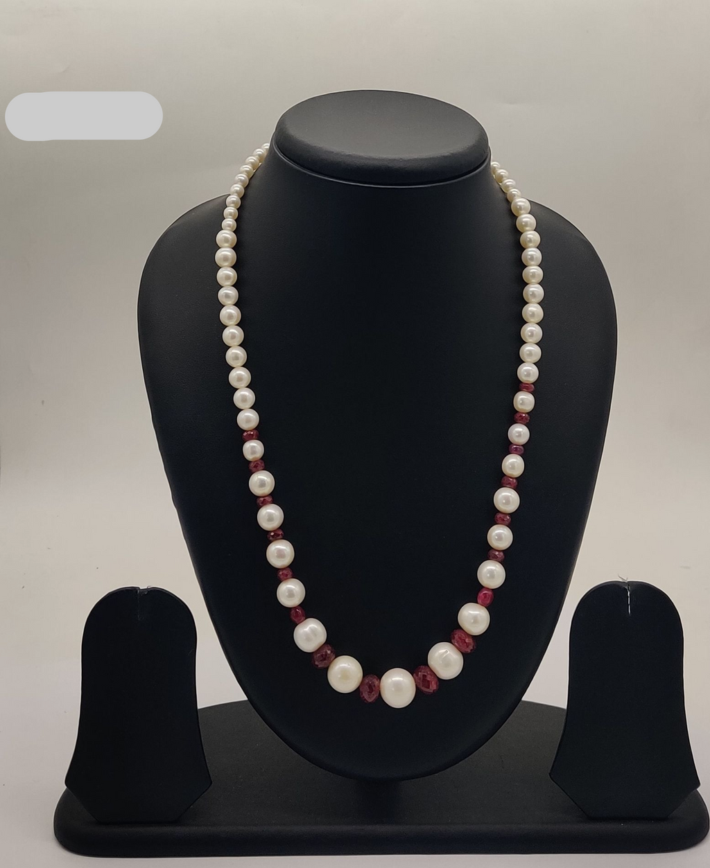 freshwater pearl necklace with graduated white pearls and red bead accents in single strand design