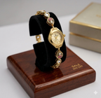 gold tone designer bracelet watch for women with pink stone accents