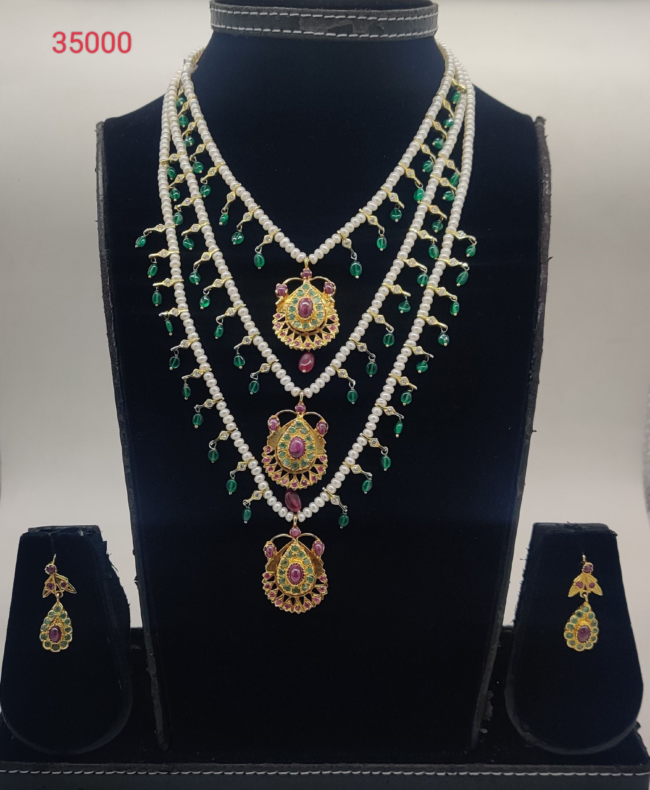 temple freshwater pearl pendant set with green beads and triple gold pendants with stone detailing